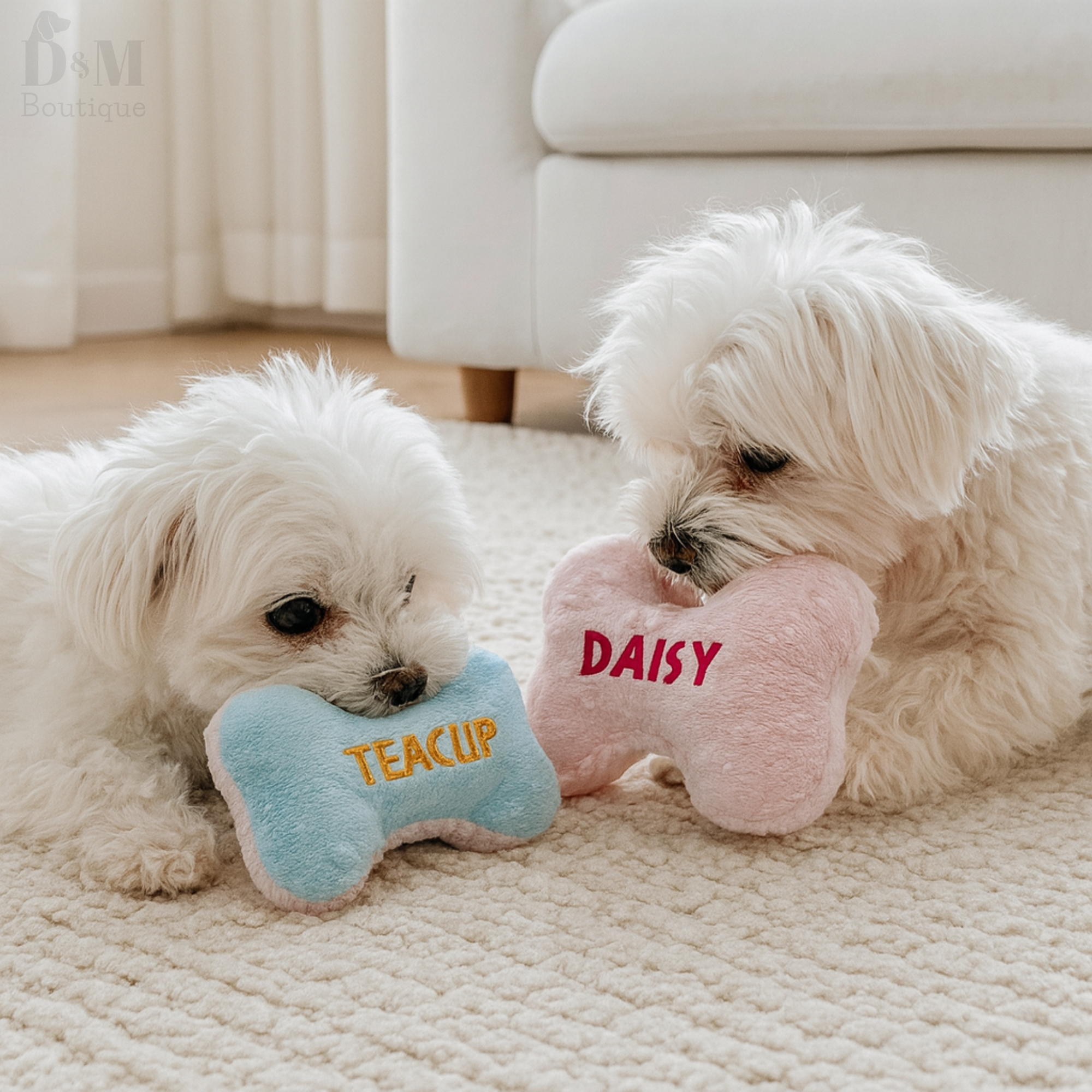 Two small white dogs playing with personalized dog toys on a carpeted floor.