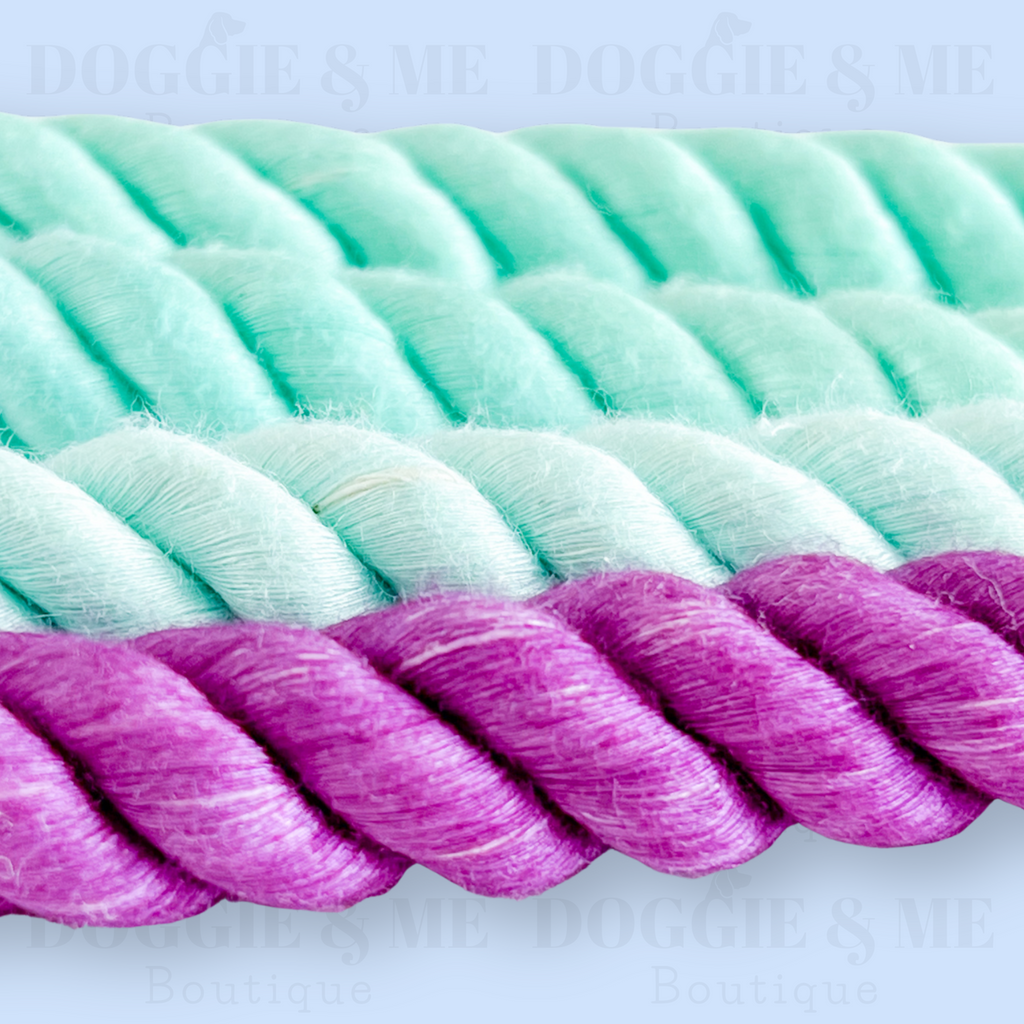 Close-up of a braided ombre turquoise-purple cotton dog leash with tan leather joints, showcasing its soft yet durable texture and gold snap hook. Available in various colors and lengths from 4ft to 5.74ft.