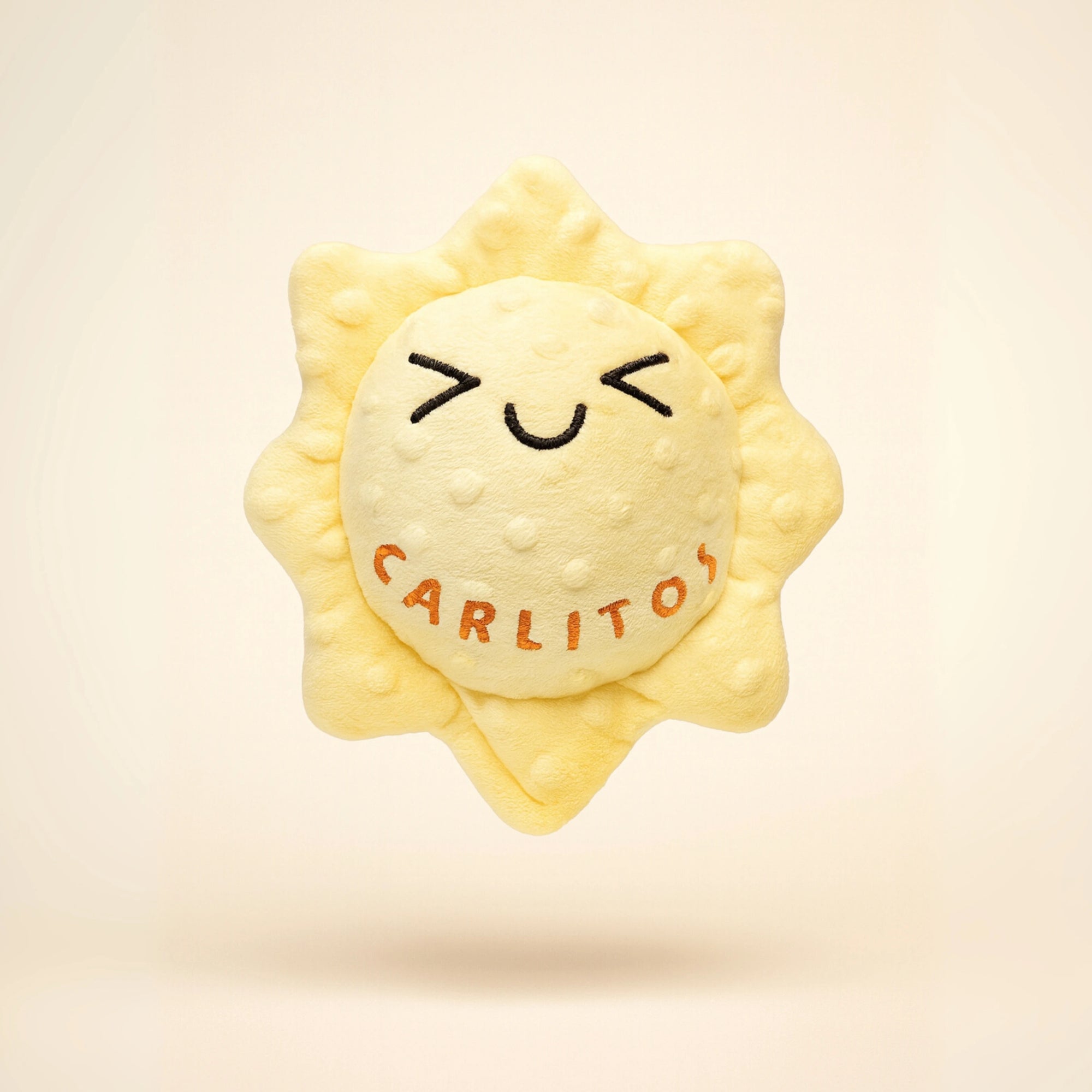 Sun-shaped plush toy with 'Carlitos' branding on a beige background