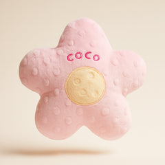 Pink textured flower-shaped toy with 'COCO' branding on a beige background