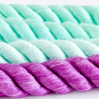 Close-up of braided rope with alternating light green and purple strands.